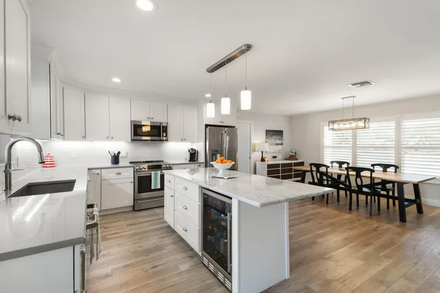 a kitchen with white cabinets sink and stainless steel appliances