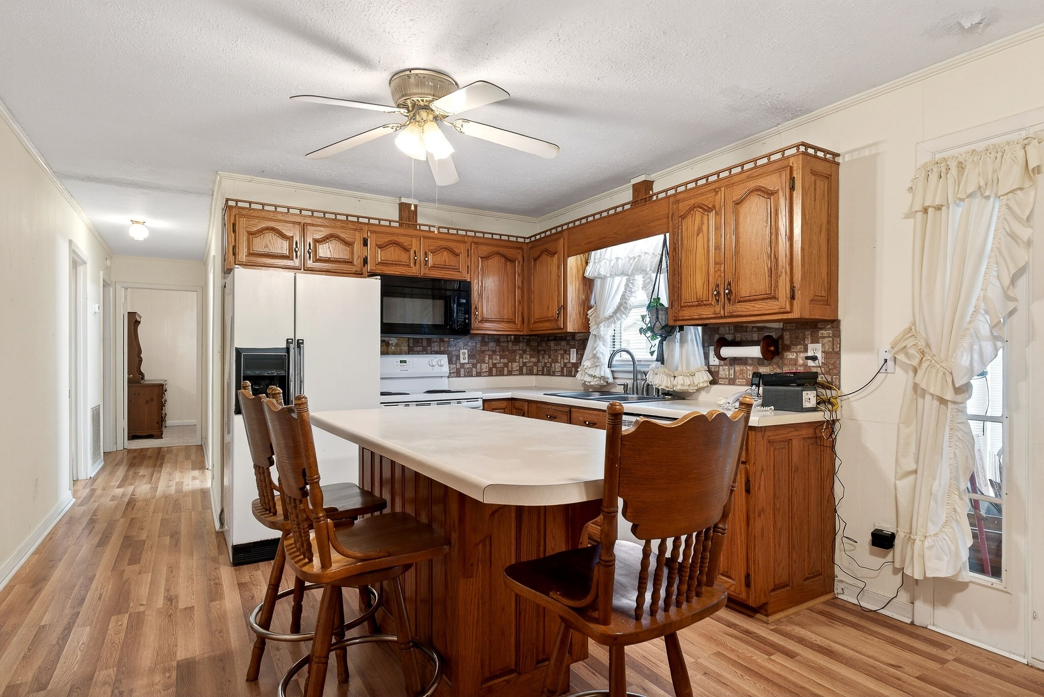4463 Crisp Springs Road McMinnville, TN 37110 - Photo 6 of 26 a kitchen with stainless steel appliances granite countertop a stove top oven a refrigerator a sink and a dining table with wooden floor