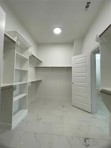 a view of walk in closet with empty racks