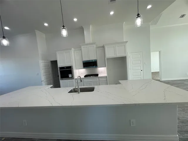 a kitchen with kitchen island a sink stainless steel appliances and cabinets