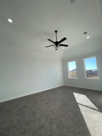 an empty room with windows and fan