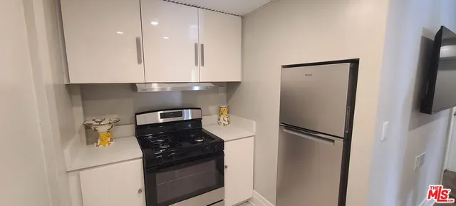 a kitchen with a refrigerator and a stove