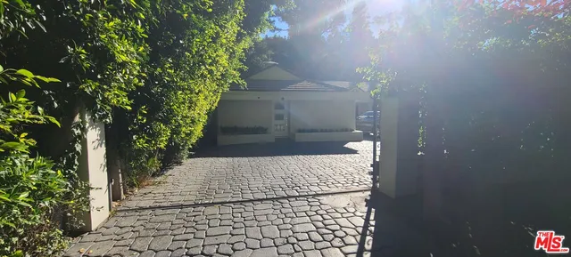 a view of a pathway of a house with flower plants