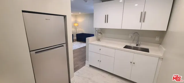 a kitchen with a refrigerator sink and cabinets