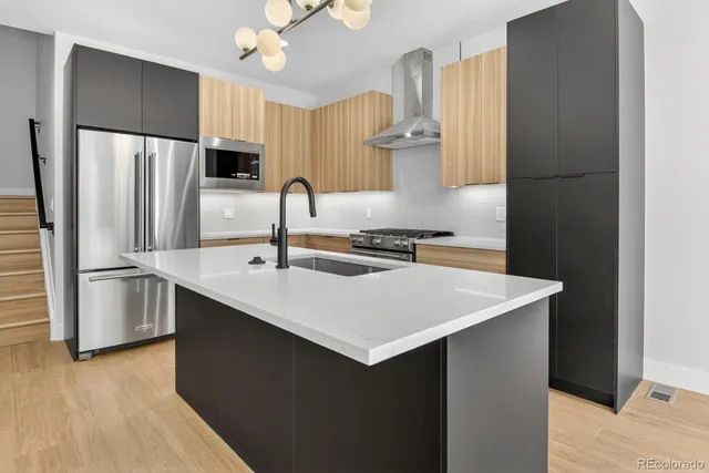 a kitchen with stainless steel appliances a sink and a refrigerator