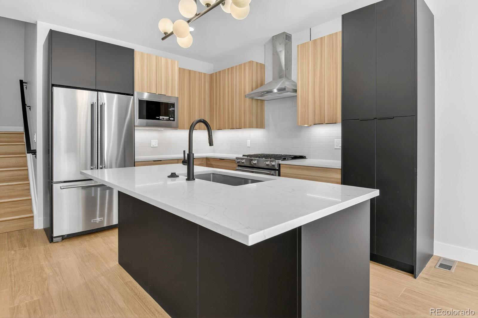 a kitchen with stainless steel appliances a sink and a refrigerator