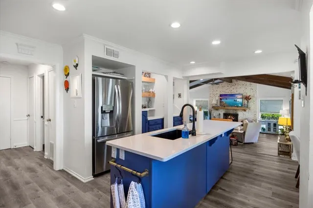 a kitchen with stainless steel appliances kitchen island granite countertop a refrigerator and a sink