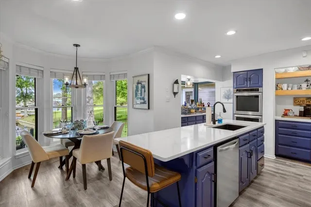 a kitchen with granite countertop a table chairs stove and kitchen view