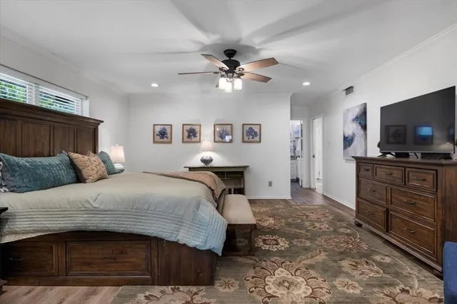 a spacious bedroom with a bed and a flat screen tv