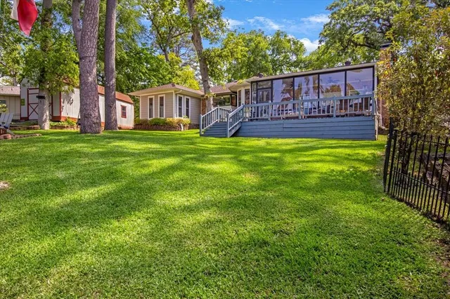 a view of a house with a yard deck and wooden fence