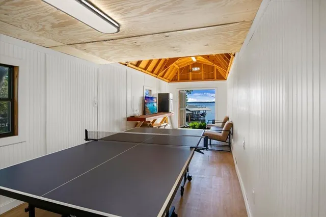 a living room with furniture pool table and wooden floor