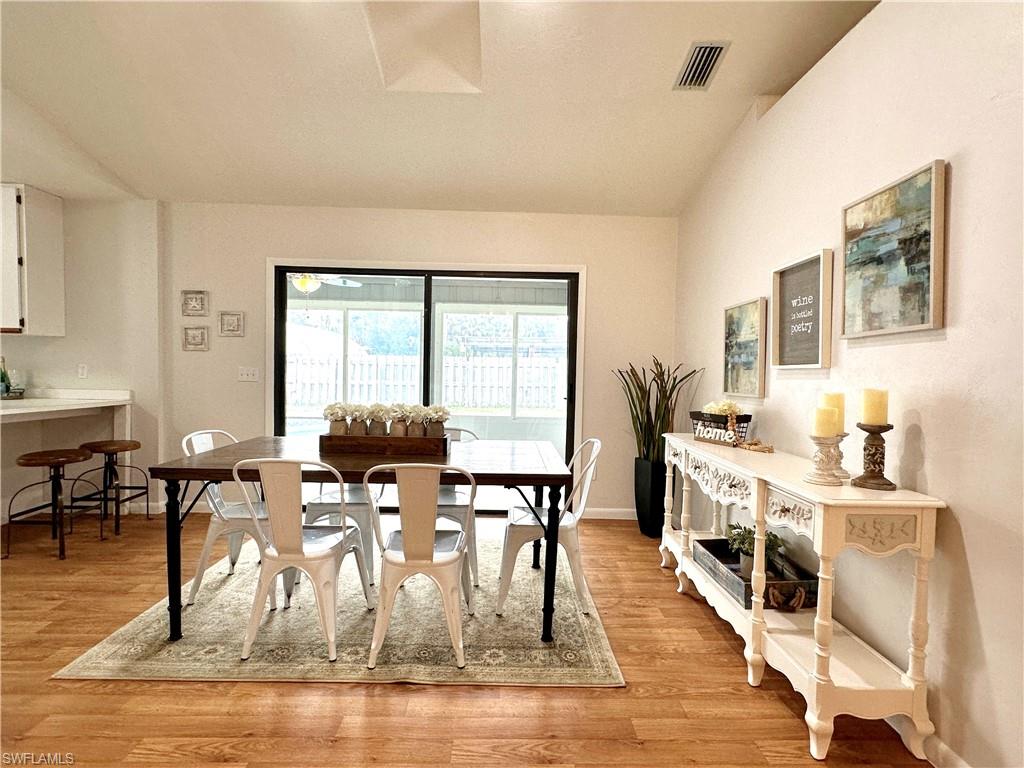 1961 Krape Road Naples, FL 34120 - Photo 16 of 44 a view of a dining room with furniture a chandelier and wooden floor