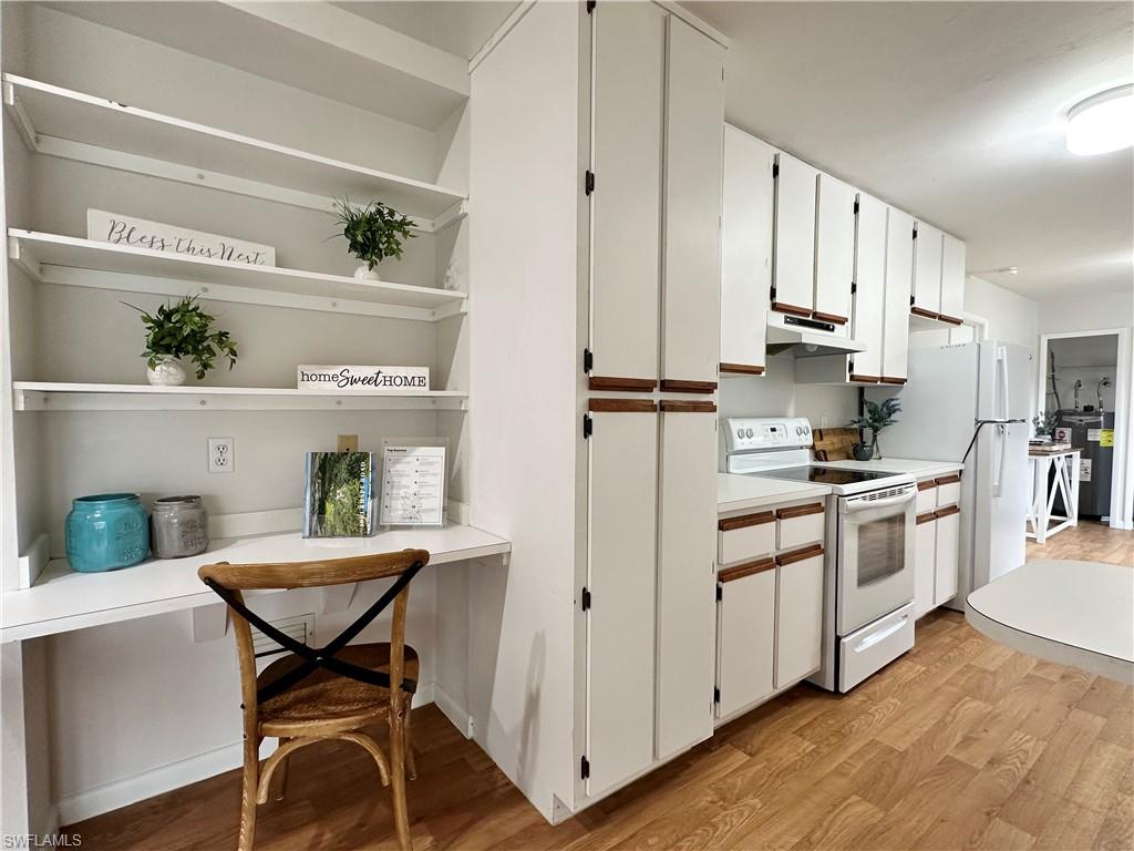 1961 Krape Road Naples, FL 34120 - Photo 23 of 44 a kitchen with stainless steel appliances kitchen island granite countertop a refrigerator a stove a sink and white cabinets with wooden floor