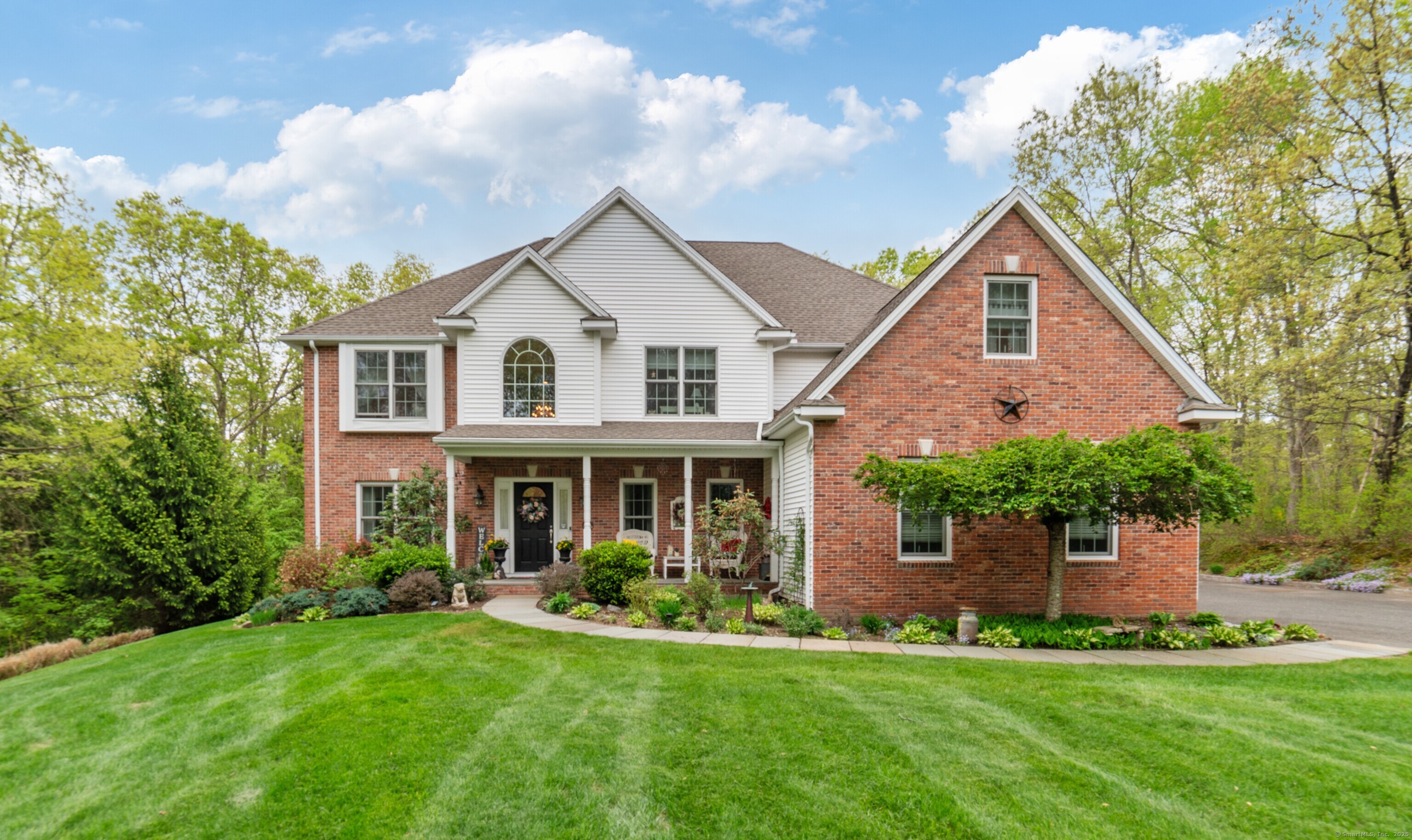 a front view of a house with a yard and trees