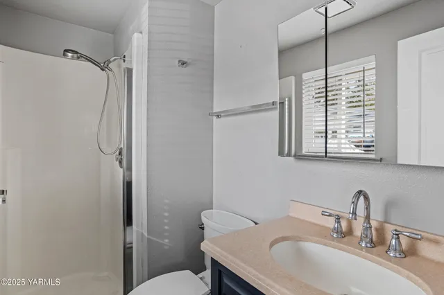 a bathroom with a granite countertop sink toilet and shower
