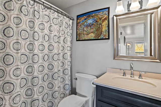a bathroom with a sink mirror vanity and toilet