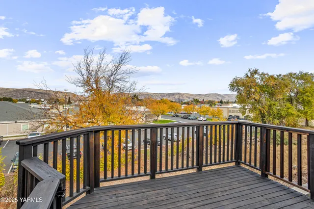 a balcony with wooden floor and city view