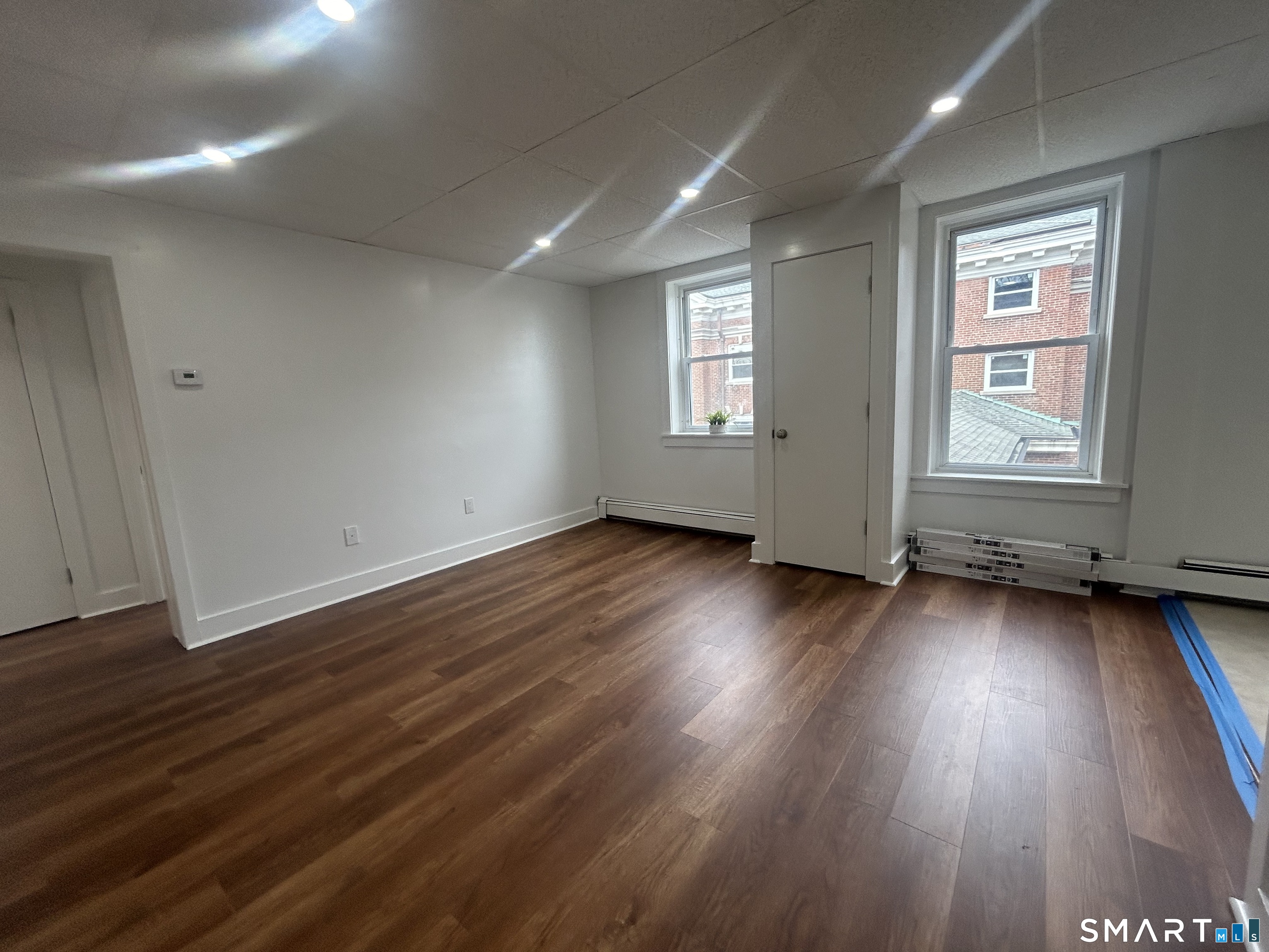 156 Garfield Avenue New London, CT 06320 - Photo 2 of 10 an empty room with wooden floor and windows