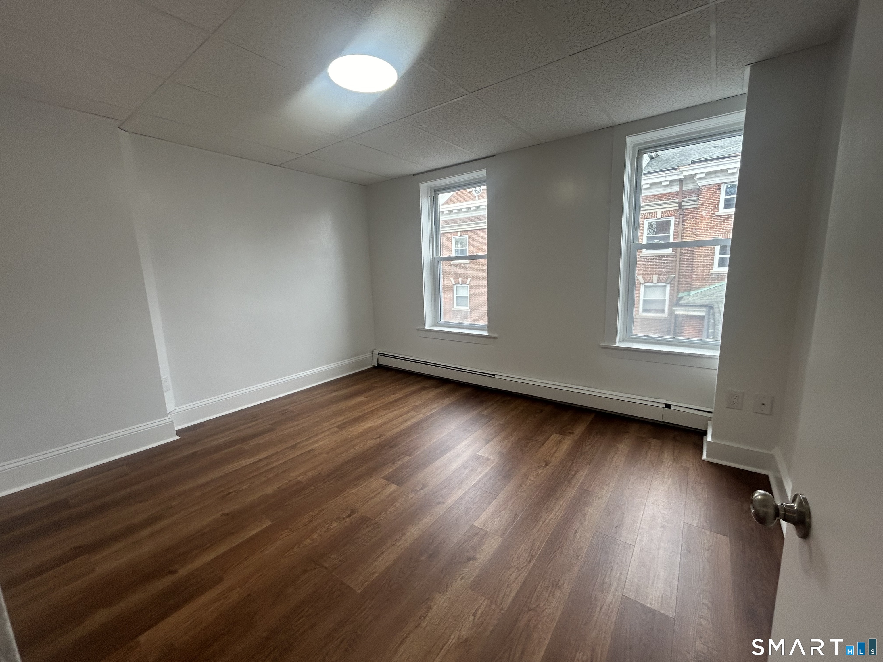 156 Garfield Avenue New London, CT 06320 - Photo 3 of 10 an empty room with wooden floor and windows