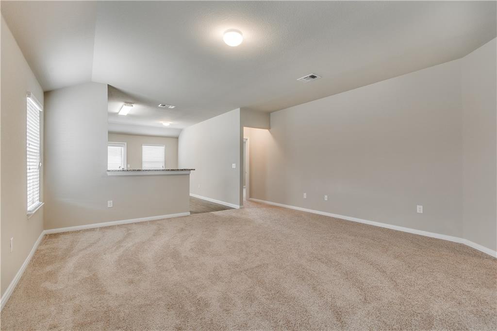 185 Voss Kyle, TX 78640 - Photo 9 of 26 a view of an empty room with wooden floor and a window