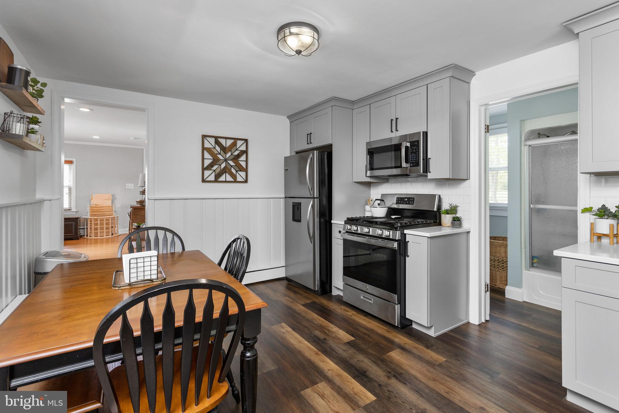 3950 Crosswicks Hamilton Square Road Hamilton, NJ 08691 - Photo 17 of 41 a kitchen with stainless steel appliances a stove a sink dishwasher a refrigerator with a dining table and chairs