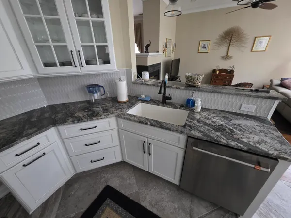 a kitchen with granite countertop white cabinets and white appliances