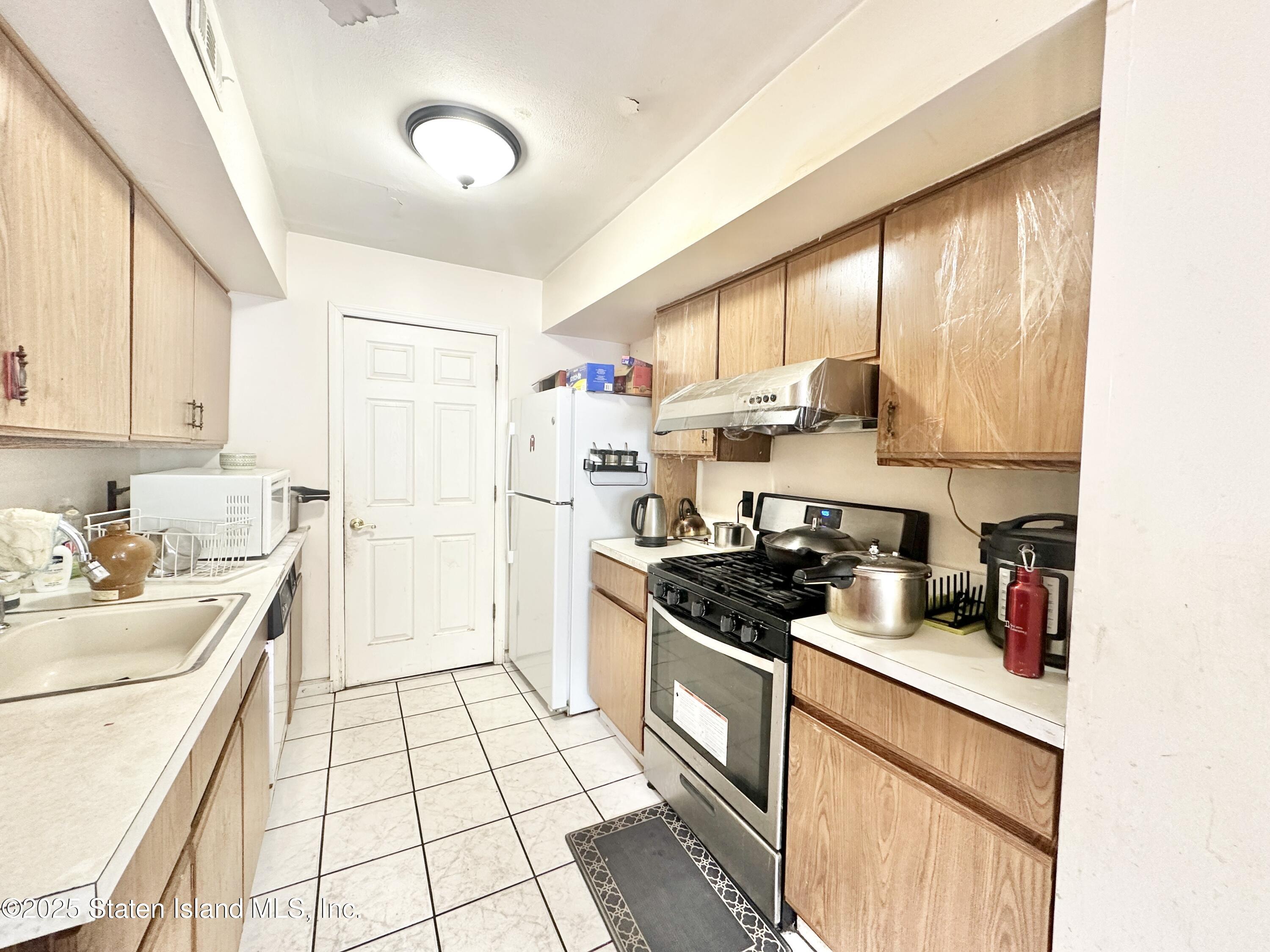 699 Elbe Avenue Staten Island, NY 10304 - Photo 2 of 8 a kitchen with a sink cabinets and appliances