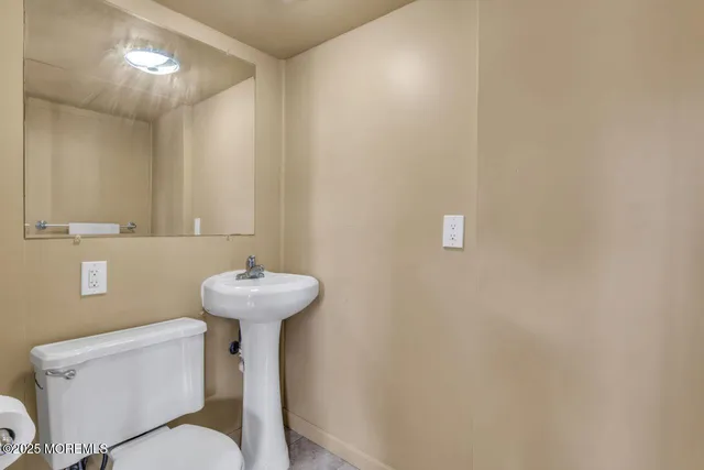 a bathroom with a sink a toilet and a mirror