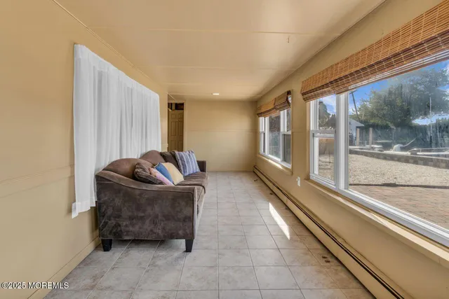 a living room with furniture a floor to ceiling window and a rug