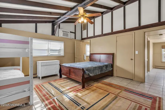 a bedroom with a bed wooden floor and window