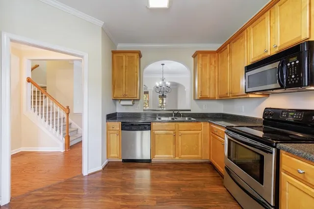 a kitchen with stainless steel appliances granite countertop a stove a sink and a microwave
