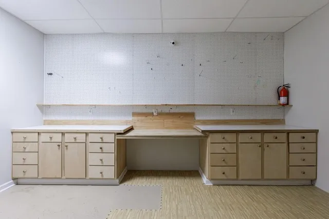 a large white kitchen with stainless steel appliances a large counter top a stove and a refrigerator