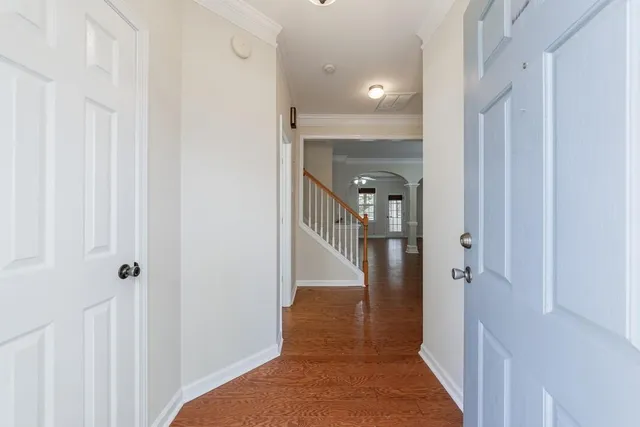 a view of a hallway with white walls and stairs