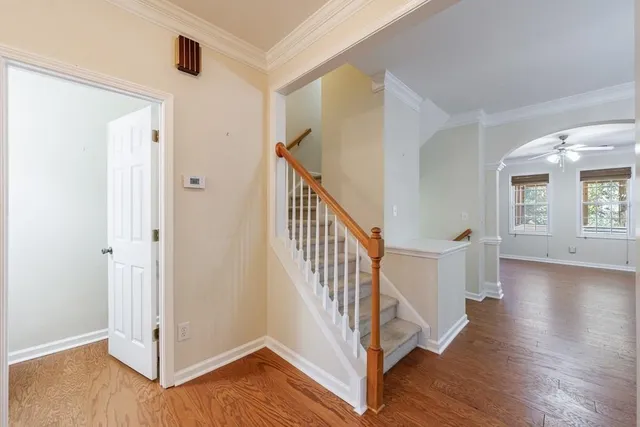 a view of a hallway with hardwood floor and stairs