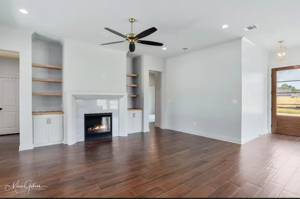 a kitchen that has a lot of white cabinets and wooden floor