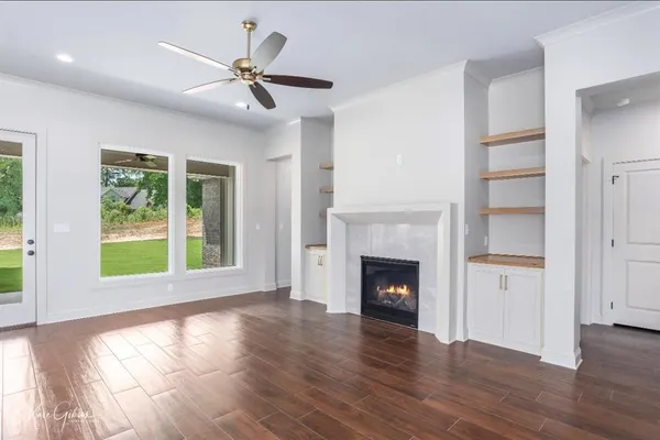 a view of empty room with a fireplace and wooden floor