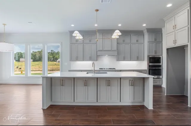a large kitchen with kitchen island a sink stainless steel appliances and cabinets