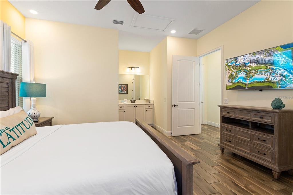 8063 Knee Deep Road Kissimmee, FL 34747 - Photo 11 of 24 a spacious bedroom with a bed and a flat screen tv