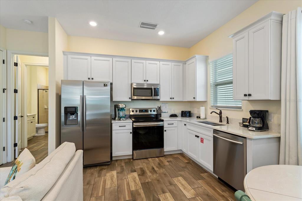 8063 Knee Deep Road Kissimmee, FL 34747 - Photo 6 of 24 a kitchen with a sink white cabinets and stainless steel appliances