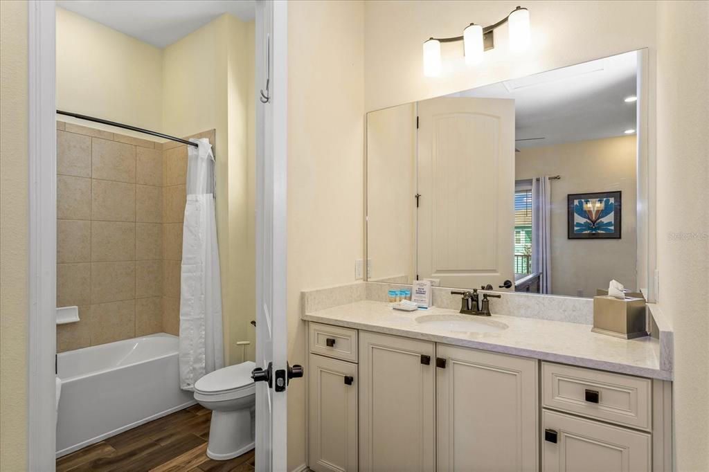 8063 Knee Deep Road Kissimmee, FL 34747 - Photo 10 of 24 a bathroom with a sink a toilet a mirror a bathtub and shower