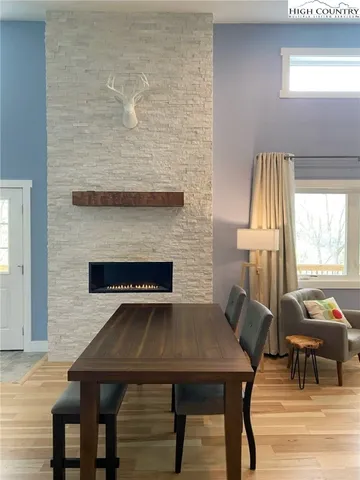 a living room with a table chairs and a fireplace