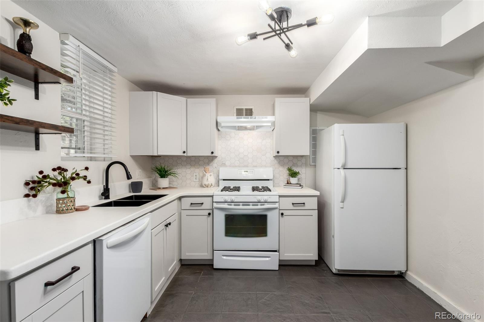 1284 Columbine Street, Unit 2 Denver, CO 80206 - Photo 16 of 34 a kitchen with stainless steel appliances granite countertop white cabinets a stove a sink and dishwasher
