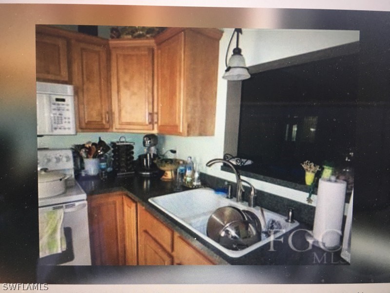 7489 Pebble Beach Road Fort Myers, FL 33967 - Photo 2 of 7 a kitchen with a sink a stove and a cabinets