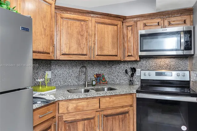 a kitchen with stainless steel appliances granite countertop a sink a stove and a microwave