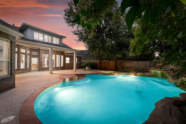 a view of a house with backyard swimming pool and sitting area