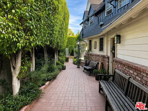 a view of a patio with couches and table and chairs and potted plants