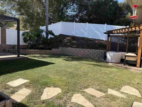 a view of a backyard with plants and patio