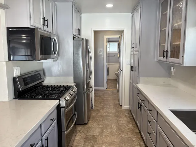 a kitchen with stainless steel appliances granite countertop a stove a microwave and a refrigerator