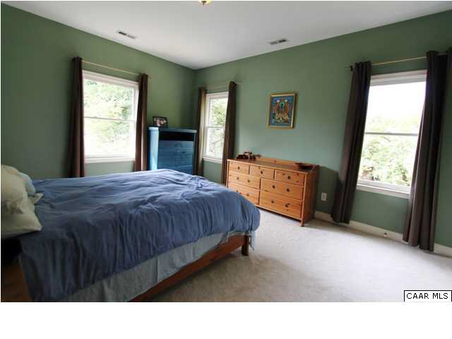 129 Goodman Street Charlottesville, VA 22902 - Photo 16 of 25 a spacious bedroom with a bed and a dresser next to a window