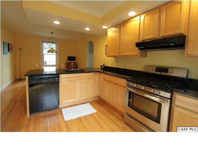 129 Goodman Street Charlottesville, VA 22902 - Photo 10 of 25 a kitchen with granite countertop a stove a sink and a microwave